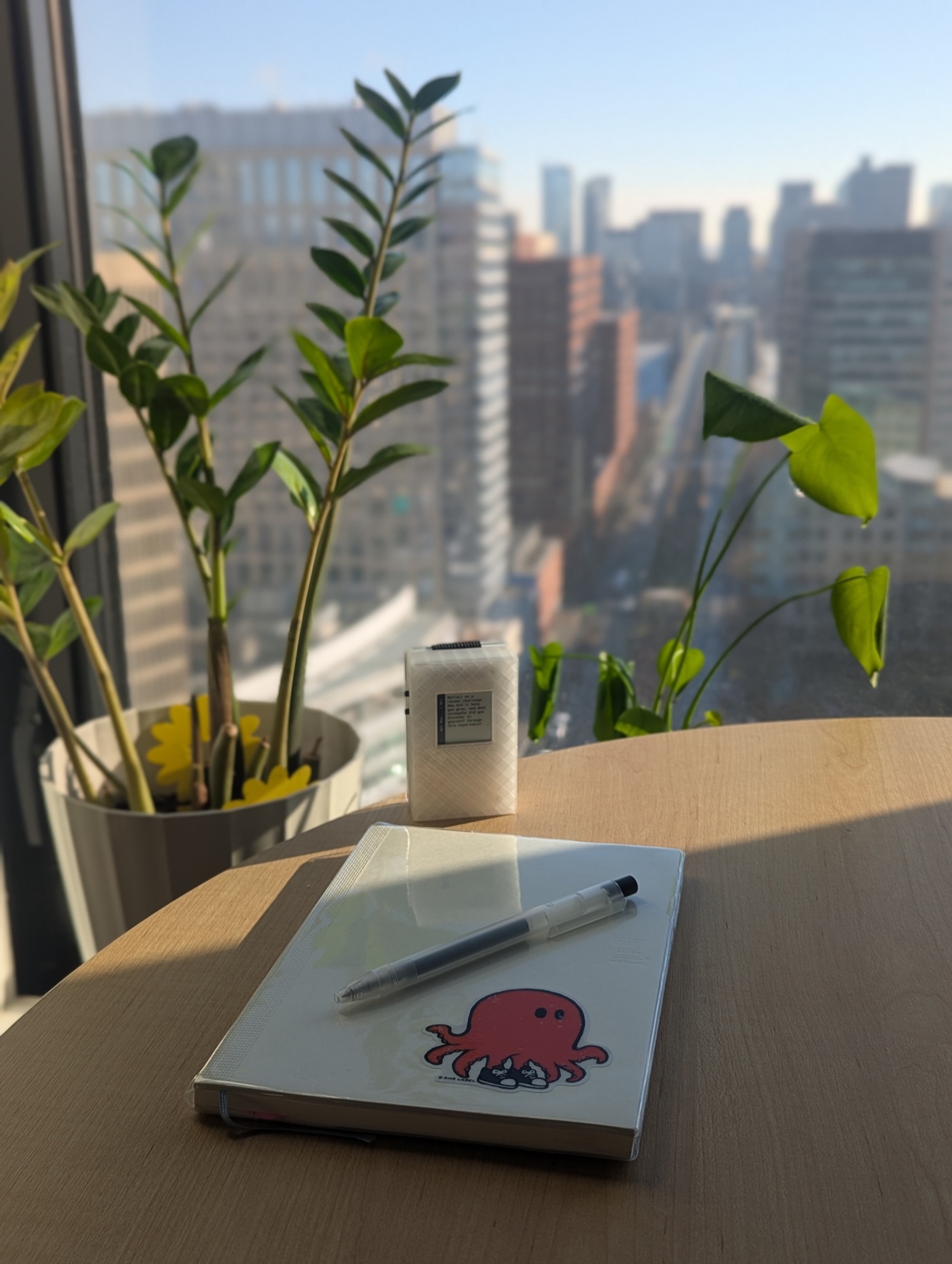 The Glyph wallet showing a morning journaling prompt next to an open notebook and pen